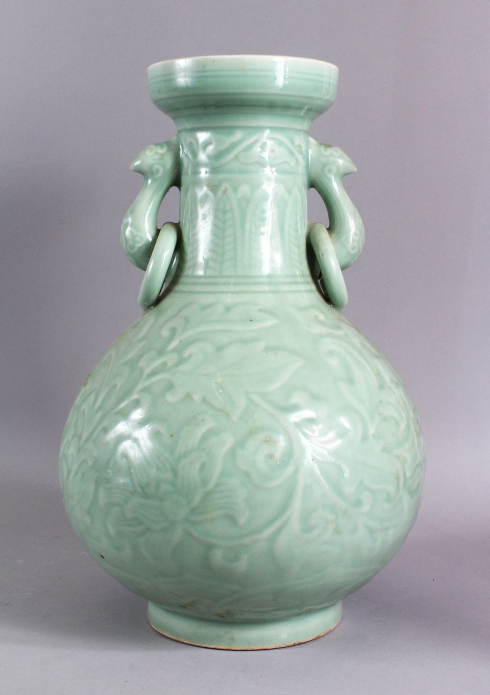 A LARGE CHINESE CELADON PORCELAIN TWIN HANDLE VASE, the body with carved floral decoration beneath a