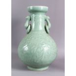A LARGE CHINESE CELADON PORCELAIN TWIN HANDLE VASE, the body with carved floral decoration beneath a