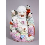 A CHINESE REPUBLIC STYLE FAMILLE ROSE PORCELAIN FIGURE OF BUDDHA, seated with boys, 17cm high