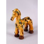 A TURKISH CANAKKALE POTTERY FIGURE OF A HORSE, with green and brown splash decoration upon a biscuit