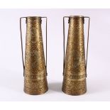 A PAIR OF PERSIAN BRASS ENGRAVED VASES, with twin handles, carved panels of figures and foliage,