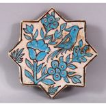 AN IRANIAN TURQUOISE GLAZE STAR FORMED POTTERY TILE, decorated with bird upon branches, 17cm