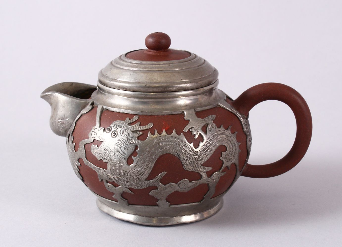 A CHINESE YIXING CLAY & WHITE METAL DRAGON TEAPOT, The body of the teapot encapsulated with a carved