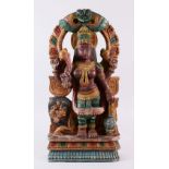 AN INDIAN CARVED WOOD & POLYCHOME FIGURE OF DURGA, depicted with a comical faced lion, four arms