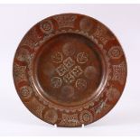 A 19TH CENTURY ISLAMIC CALLIGRAPHIC COPPER DISH, with floral motif and panels of calligraphy, 24cm
