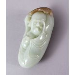 A CHINESE CARVED JADE FIGURE / PENDANT OF AN IMMORTAL, holding an object and a fan above his head,