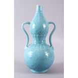 A CHINESE PALE BLUE GLAZED PORCELAIN DOUBLE GOURD VASE, the body carved with lotus decoration and