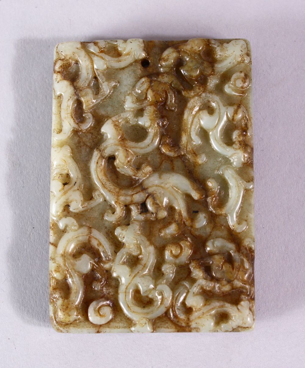 A 19TH CENTURY SPECKLED JADE RECTANGLAR TABLET, carved with scrolls, 6.5cm x 4.5cm.