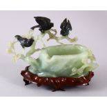 A CHINESE CARVED JADE BIRD FORMED ASHTRAY, carved as a tree stump with pine growth and birds