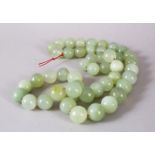 A SET OF CHINESE CARVED CELADON JADE BEAD NECKLACE, comprising 49 carved beads of varying size.