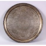 A 19TH CENTURY INDIAN WHITE METAL CHASED FLORAL DISH, decorated with native floral scenes 34cm