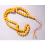 A CHINESE QING DYNASTY CARVED AMBER PRAYER BEADS / ROSARY NECKLACE, comprising 66 beads, 3 spacers