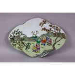 A CHINESE FAMILLE ROSE PORCELAIN BOYS TILE SECTION, of quatrelobe form, deppicting boys playing in a