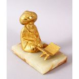 A TURKISH GILT BRONZE FIGURE OF A SEATED FIGURE, seated with a quran stand, mounted to a stone base,
