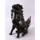 A 19TH CENTURY CHINESE BRONZE LION DOG CENSER, in a seated pose, the cover to its back, 38cm high.