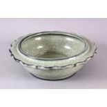 A CHINESE BARBED RIM GUAN GLAZED POTTERY DISH, the flared rim with ironwire style body decoration,