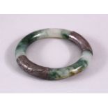 A CHINESE CARVED MOSS GREEN & WHITIE METAL BANGLE, the jade a translucent white with moss green