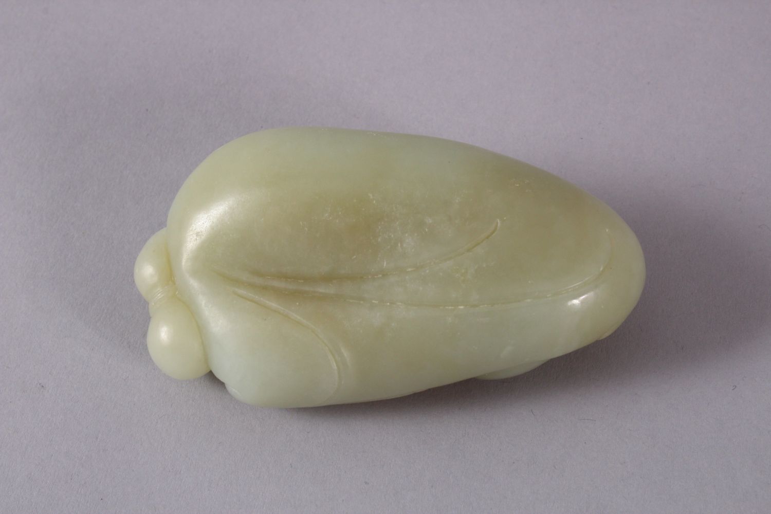 A CHINESE CARVED JADE FIGURE / PENDANT OF BUDDHA, in a recumbent position holding a tied double - Image 3 of 3