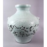A CHINESE MING STYLE CELADON CARVED OPENWORK JAR, the body carved with dragons and lotus, with