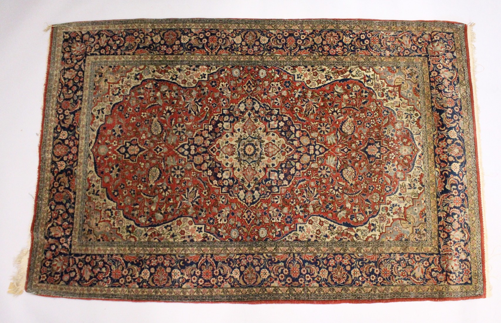 A GOOD PERSIAN RUG, early 20th Century red ground with stylised floral decoration. 7ft x 4ft 5ins.