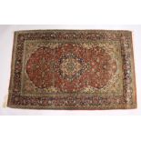 A GOOD PERSIAN RUG, early 20th Century red ground with stylised floral decoration. 7ft x 4ft 5ins.