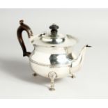 A CIRCUALR SILVER TEA POT with waved rim and wooden handles. London 1902, maker C.B. Weighs 14oz.