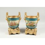A GOOD PAIR OF SEVRES PORCELAIN AND ORMOLU TWO HANDLED CACHE POTS. 13ins high.