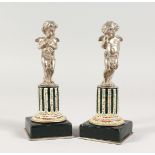 A SUPERB SMALL PAIR OF SILVERED BRONZE AND ENAMEL CUPIDS ON STANDS 6Ins high