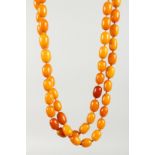 A LONG VICTORIAN AMBER NECKLACE OF 66 BEADS