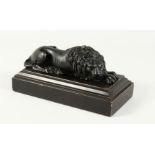 A GRAND TOUR BRONZE LION 8ins long, on a wooden base.