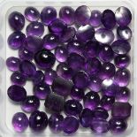 A BOX OF CARBOUCHON AMETHYST STONES