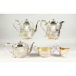 A VICTORIAN SILVER FIVE PIECE TEA SET a with scroll and repousse decoration. Initialed A. Comprising