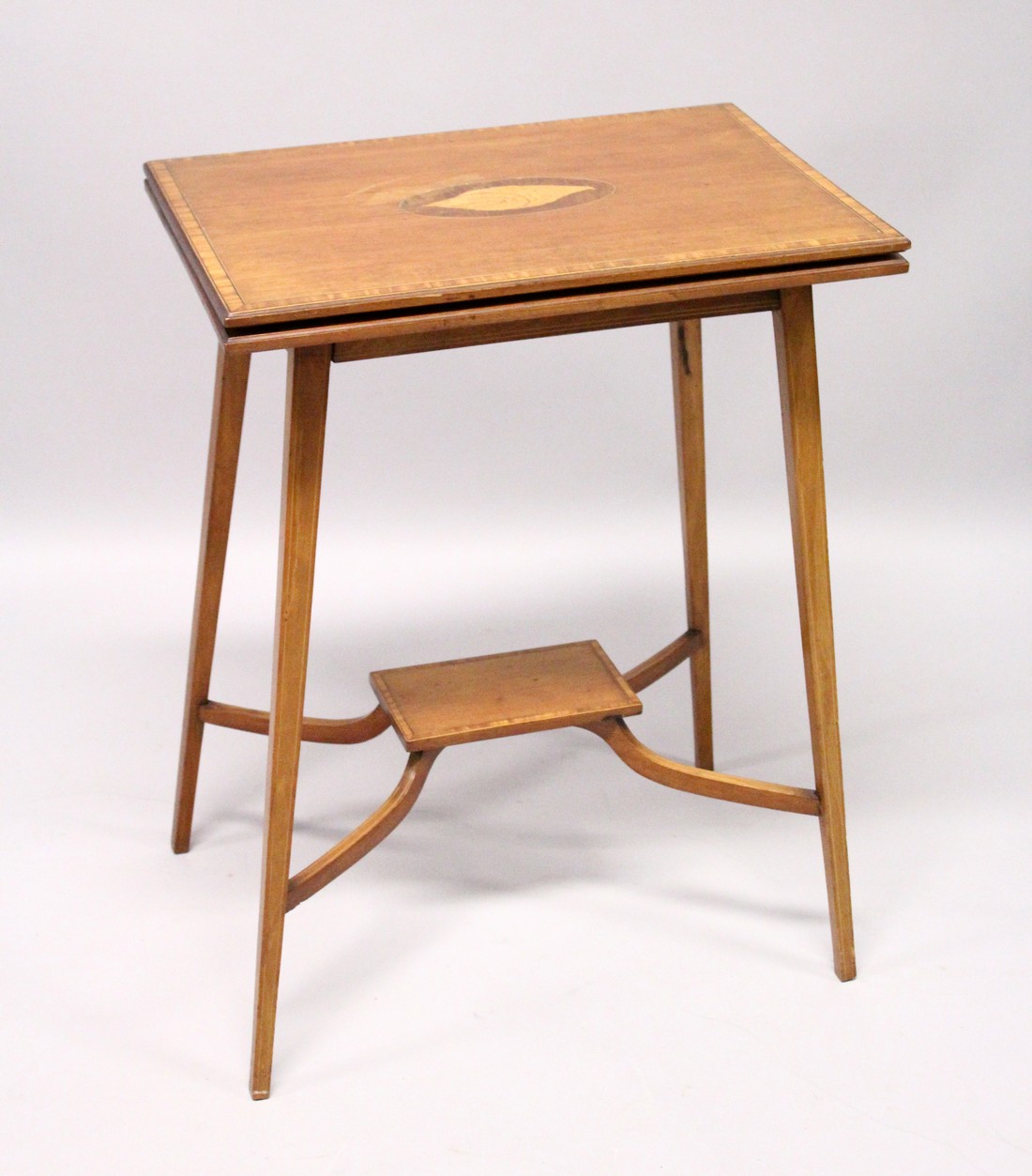 AN EDWARDIAN MAHOGANY FOLDING TOP TEA TABLE, on tapering legs with under tier. 1ft 9ins long.