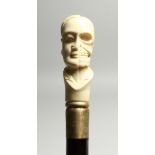 A BONE WALKING STICK 'HALF FACE, HALF SKULL' 35ins high