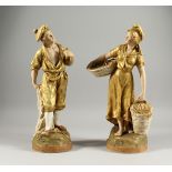 A PAIR OF ROYAL DUX FIGURES OF A MAN HOLDING A PIPE and a woman carrying two baskets. Triangular