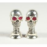 A PAIR OF .800 SKULL SALT AND PEPPERS
