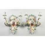 A GOOD PAIR OF MEISSEN PORCELAIN TWO LIGHT WALL SCONCES with cupid and encrusted with flowers and