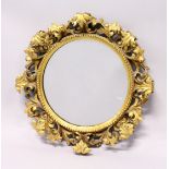 A GOOD 19TH CENTURY FLORENTINE GILT FRAMED CIRCULAR MIRROR, with well carved leafwork frame. 1ft