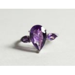 A SILVER THREE STONE AMETHYST RING