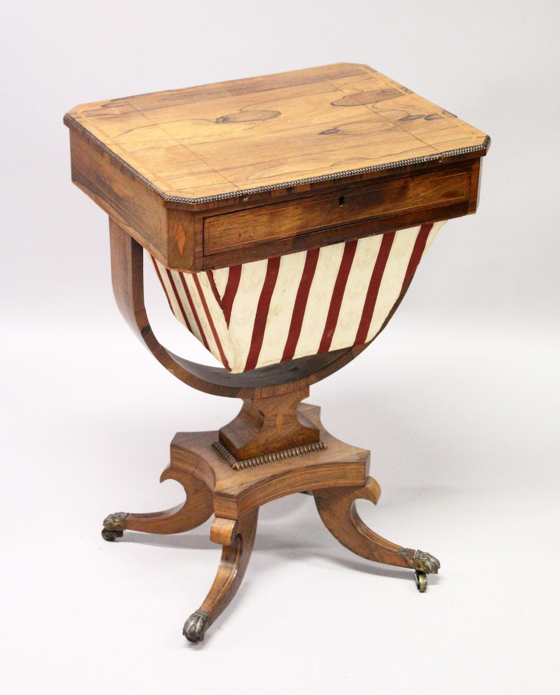 A REGENCY ROSEWOOD SEWING TABLE, with reversible Backgammon top , sliding drawer and sewing bag on