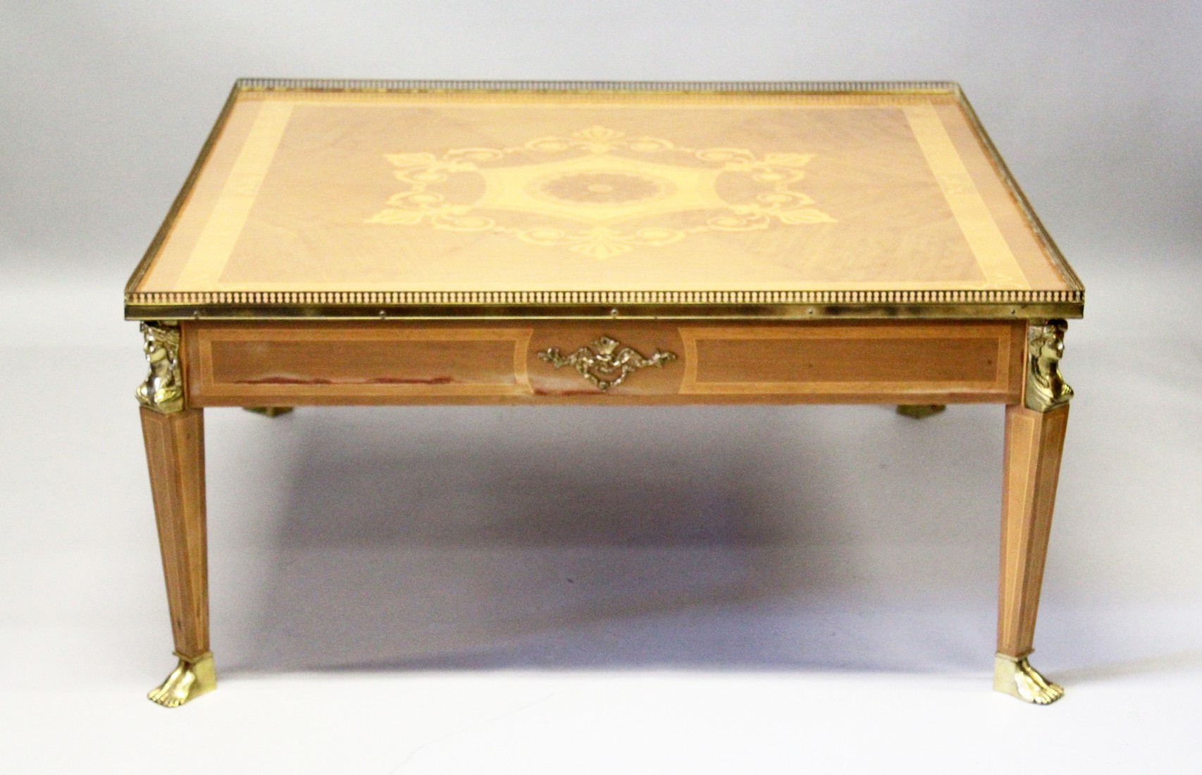 A LOUIS XVITH SQUARE TOP COFFEE TABLE, with inlaid topand brass grill on Egyptian brass legs with