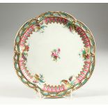 AN ENGLISH PORCELAIN PLATE with pierced border and painted with roses. 9ins diameter.