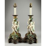 A LARGE PAIR OF MAJOLICA POTTERY LAMPS,with three cupids around a tree.