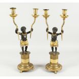 A SUPERB PAIR OF EMPIRE BRONZE AND GILT BRONZE TWO BRANCH CANDLESTICKS of nubian children holding
