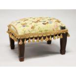 A SMALL FOOTSTOOL UPHOLSTERED with a butterfly tapestry material. 1ft 5ins long x 1ft high.