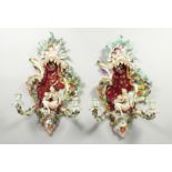 A GOOD PAIR OF MEISSEN PORCELAIN TWO LIGHT WALL SCONCES encrusted with flowers and scrolls, filled