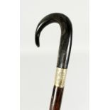 A LARGE VICTORIAN WALKING STICK with crook handle, possibly rhino, and gilt band. 42ins long.