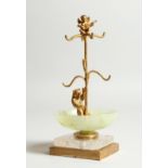 A JADE , CRYSTAL AND GILDED BEAR RING STAND on a square base 6.5ins high.