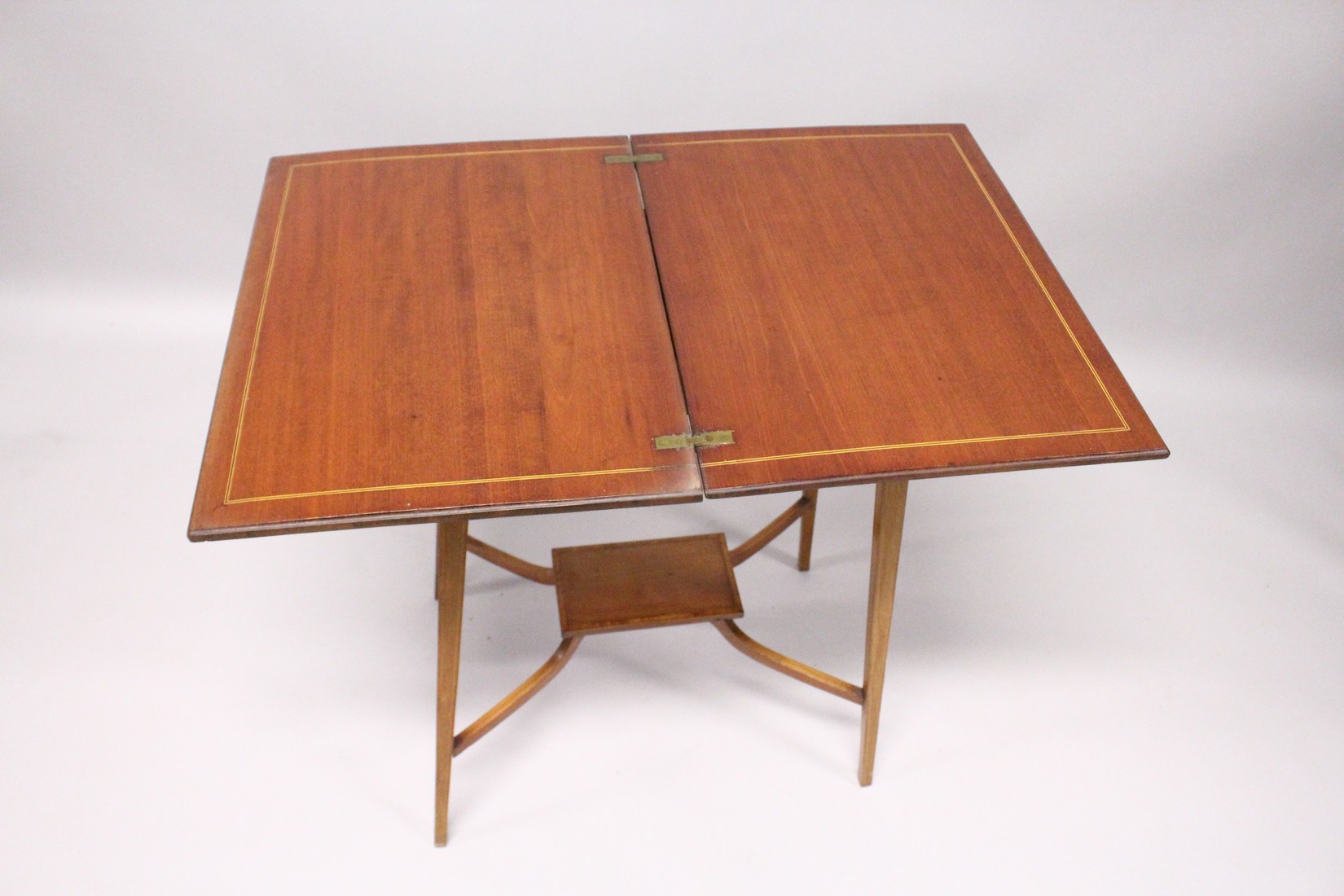 AN EDWARDIAN MAHOGANY FOLDING TOP TEA TABLE, on tapering legs with under tier. 1ft 9ins long. - Image 5 of 5