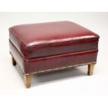 A RED LEATHER UPHOLSTERED FOOTSTOOL, on tapering square legs. 2ft 2ins x 1ft 3ins high.